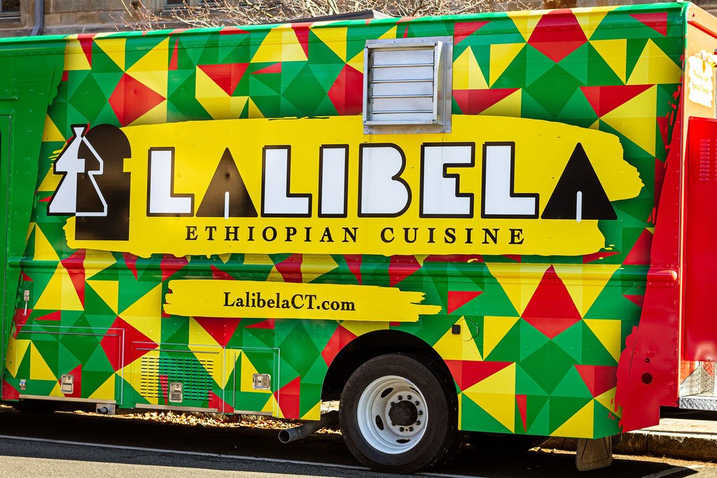The Lalibela food truck, painted in green, yellow and red triangles with the Lalibela Ethiopian Cuisine logo