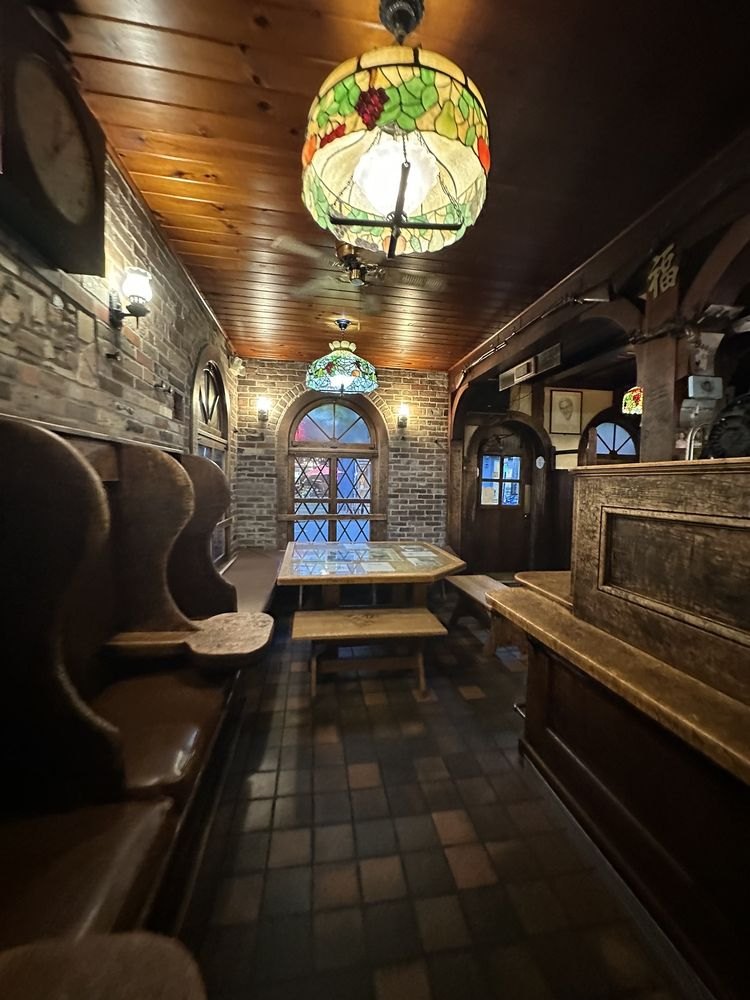 Wooden booths, a stained-glass lamp and a leaded window inside Louis’ Lunch