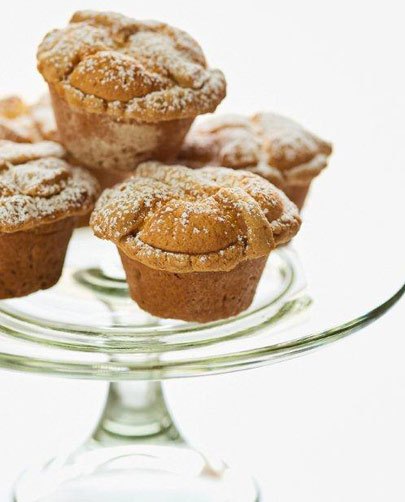 Ricotta pasticciotti dusted with powdered sugar on a glass cake stand