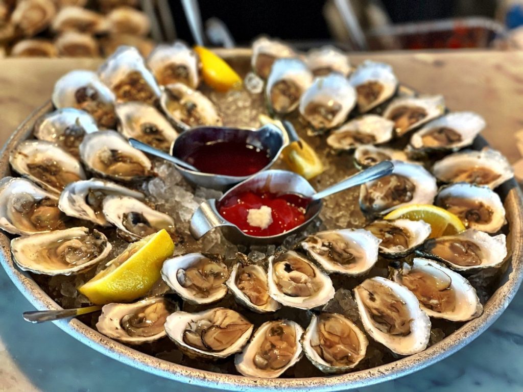 A platter of oysters on the half shell with lemon, cocktail sauce and mignonette at Shell & Bones