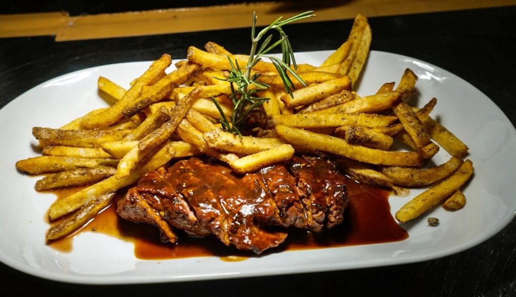 Steak frites with a pile of fries at Shell & Bones