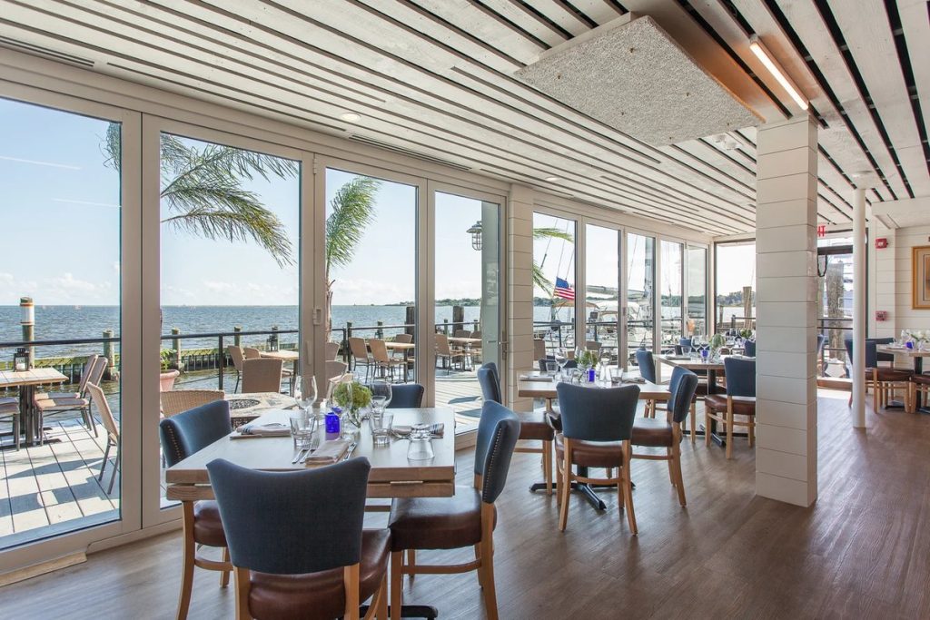 The west dining room at Shell & Bones with floor-to-ceiling windows facing the water