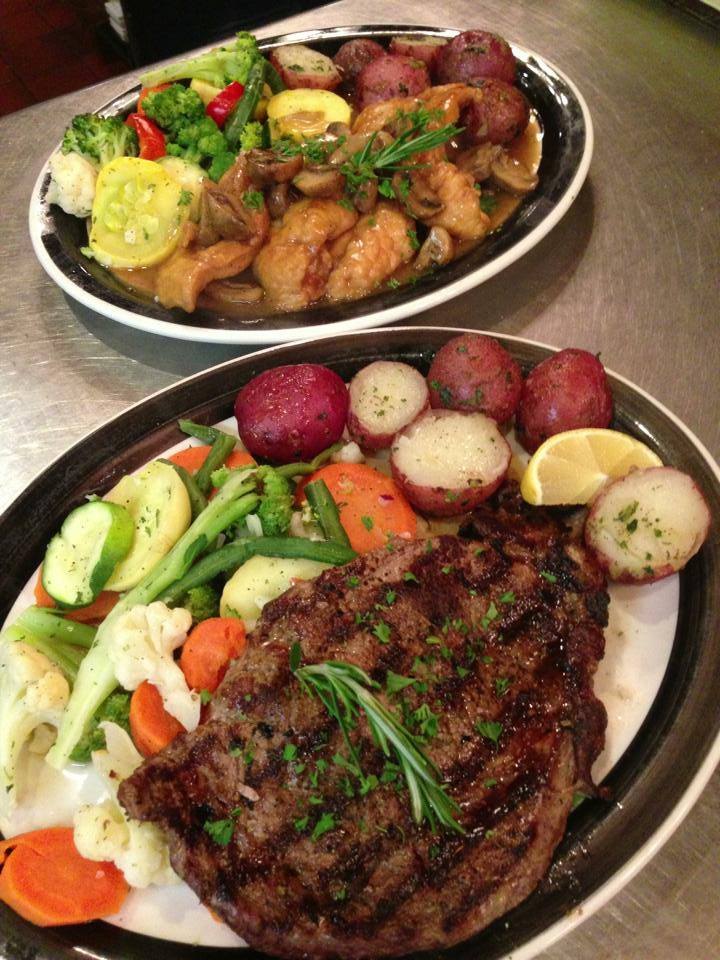A grilled steak dinner and a second dinner plate with potatoes and vegetables at Yorkside Pizza